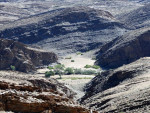 Tussen de kale rotsen zorgt de rivier voor wat groen.